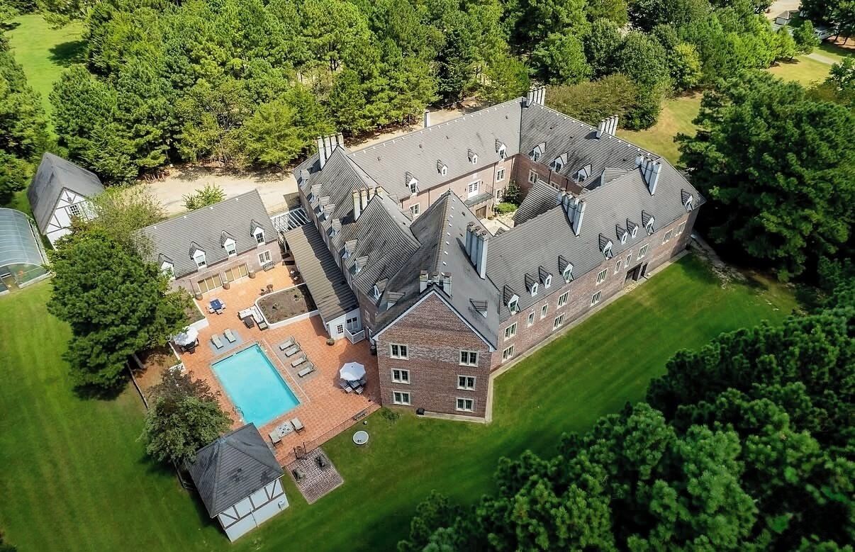 A large estate with multiple buildings, a swimming pool, and well-maintained lawns.