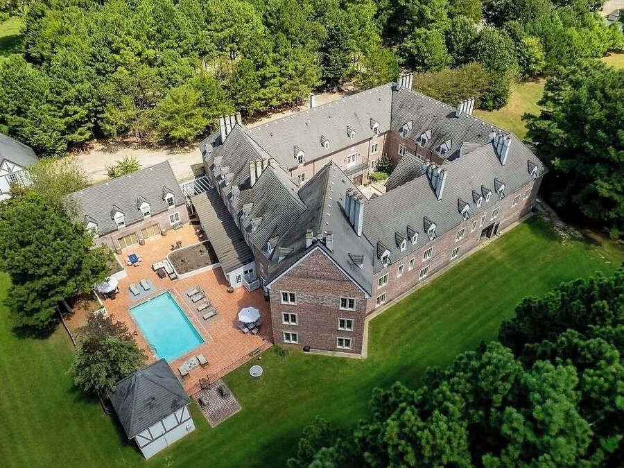 A large estate with multiple buildings, a swimming pool, and well-maintained lawns.