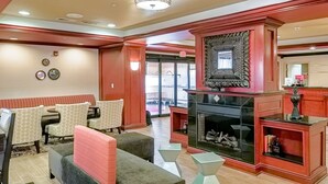 Un vestíbulo de hotel con una zona de estar, una chimenea y un mostrador de recepción.