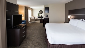 A hotel room with a large bed, a TV on a dresser, a desk with a chair, and a mirror on the wall. - Holiday Inn Express Hotel & Suites East Wichita I-35 Andover by IHG (Andover)