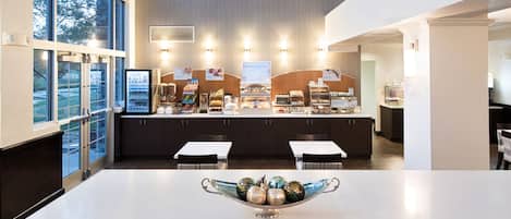 A modern breakfast bar with a variety of food options, including cereal, fruit, and bread.