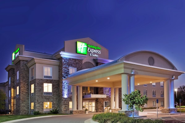 Edificio de Holiday Inn Express con fachada de piedra, acceso cubierto y señalización con el nombre del hotel.