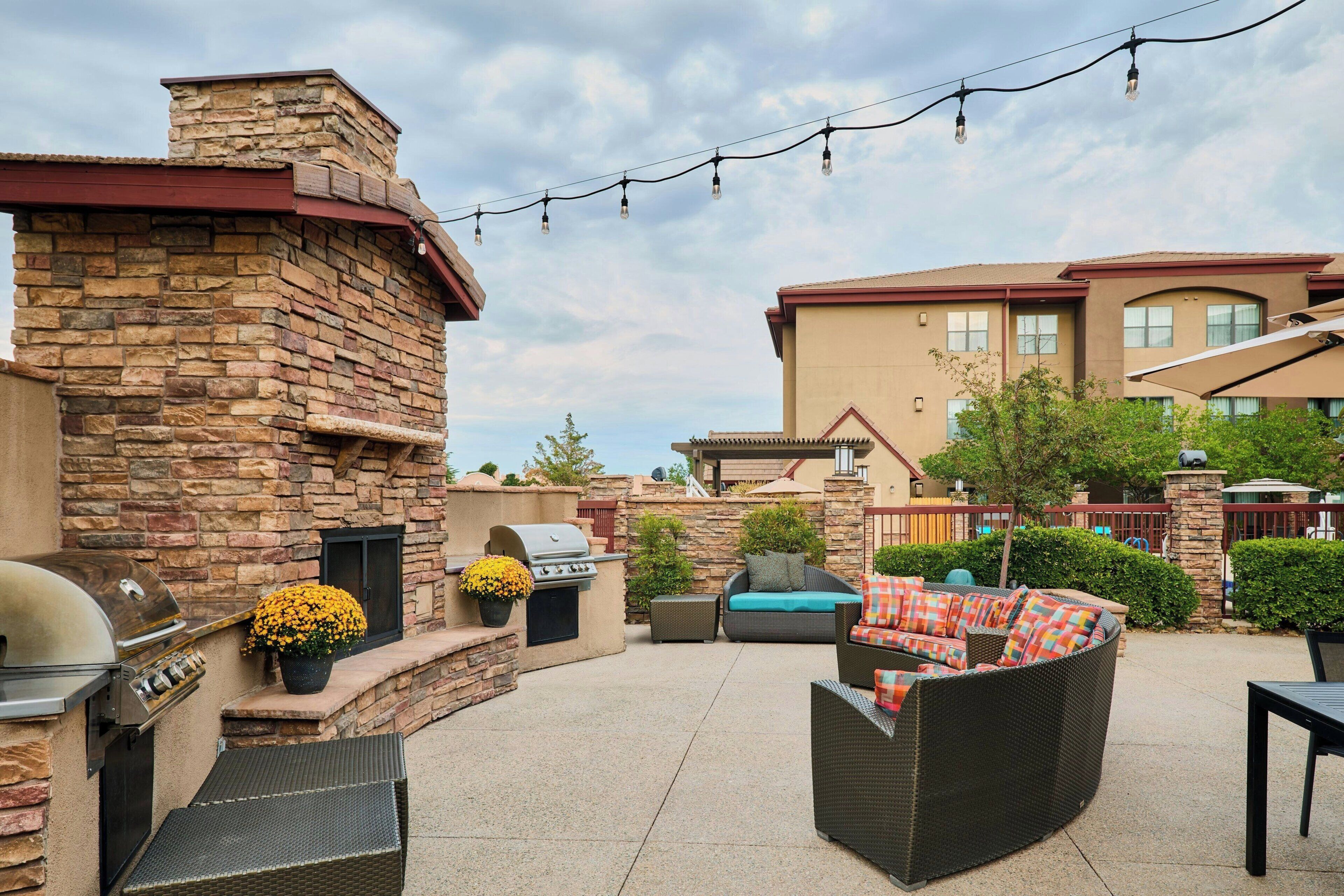 Une terrasse extérieure avec des murs en pierre, un barbecue et du mobilier d’extérieur.