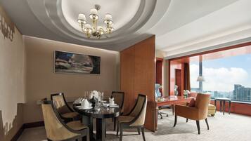 A modern dining area with a round table, chairs, and a chandelier.