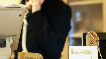 A hotel reception desk with a telephone, a keychain, and a business card.