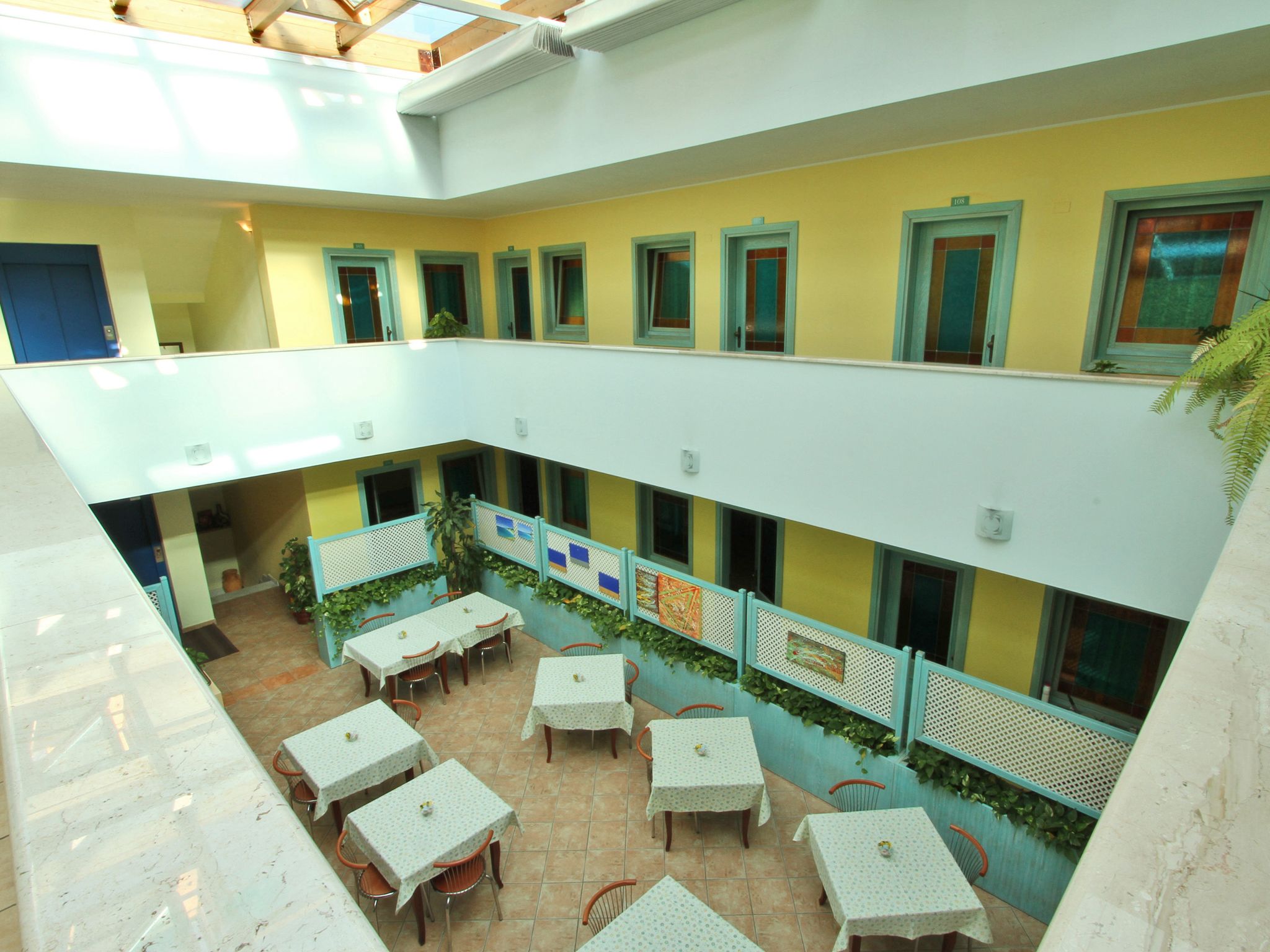 A multi-level atrium with a dining area on the lower level, featuring tables and chairs.