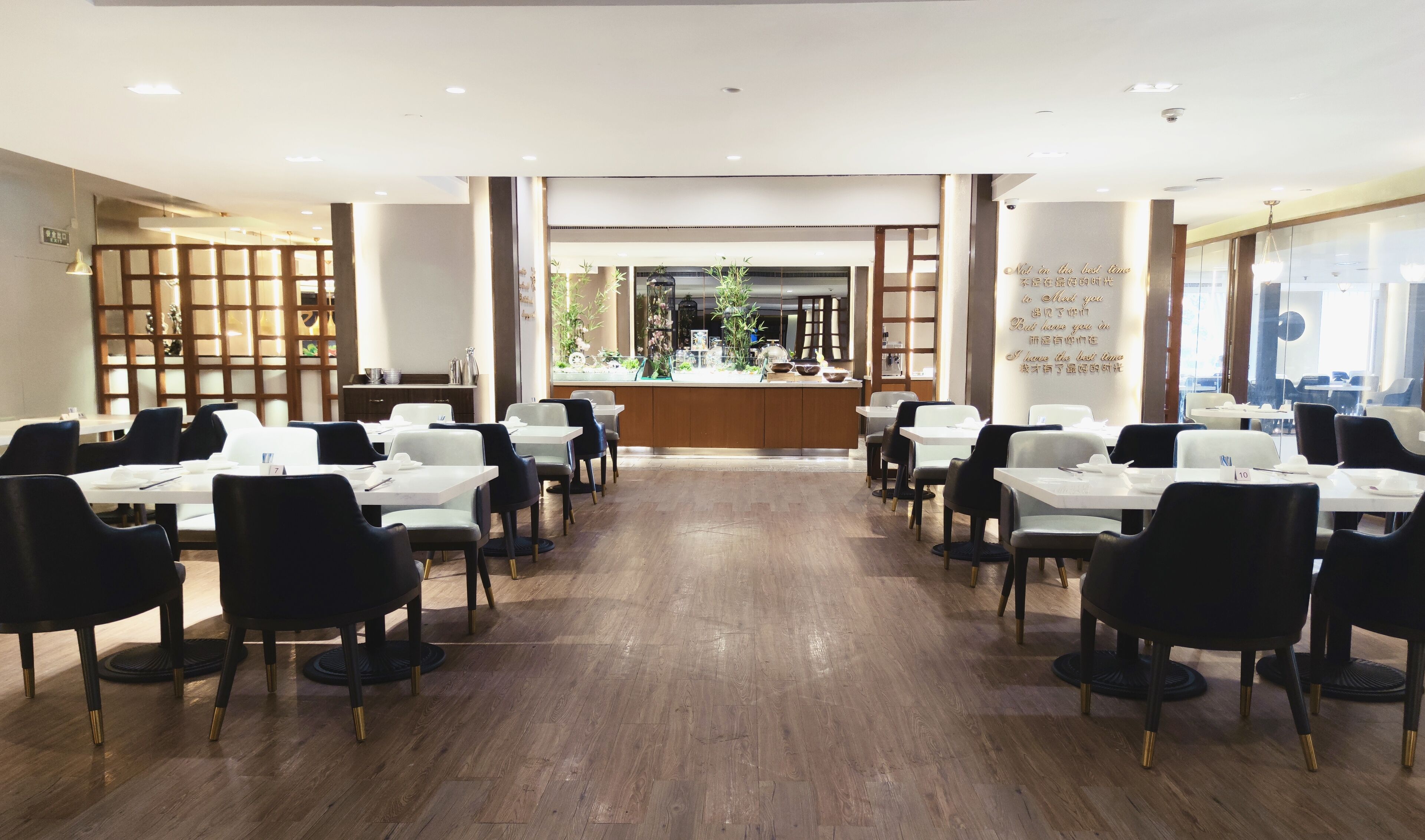 Un restaurant doté d’un comptoir central, de plusieurs tables et de chaises disposées en rangées.