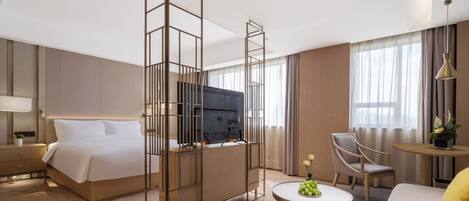 A modern hotel room with a bed, a desk, a chair, and a TV.