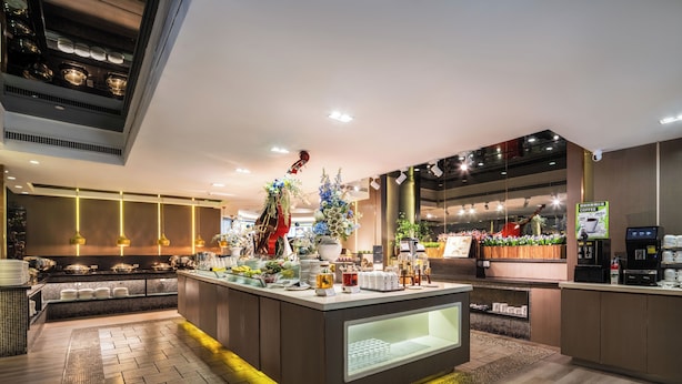 Um hall de hotel moderno com bar central, áreas de estar e espaço para café.