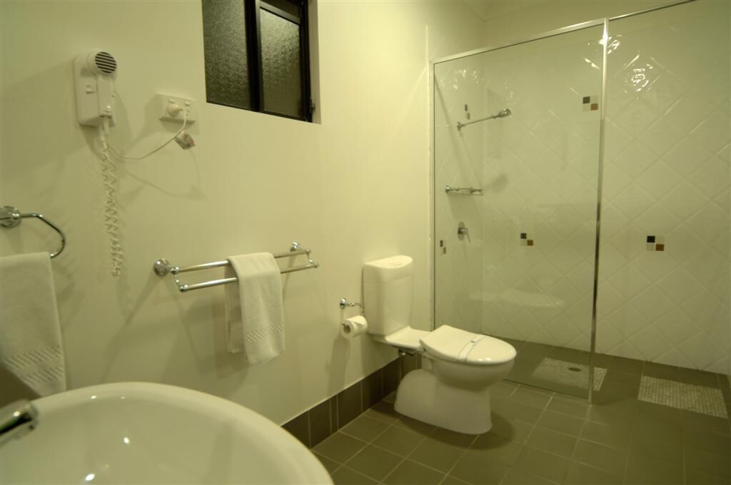 Une salle de bain équipée d’une baignoire, de toilettes et d’une douche à parois de verre.