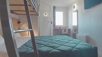 A room with a bunk bed, a desk, a chair, a window, and a mirror.