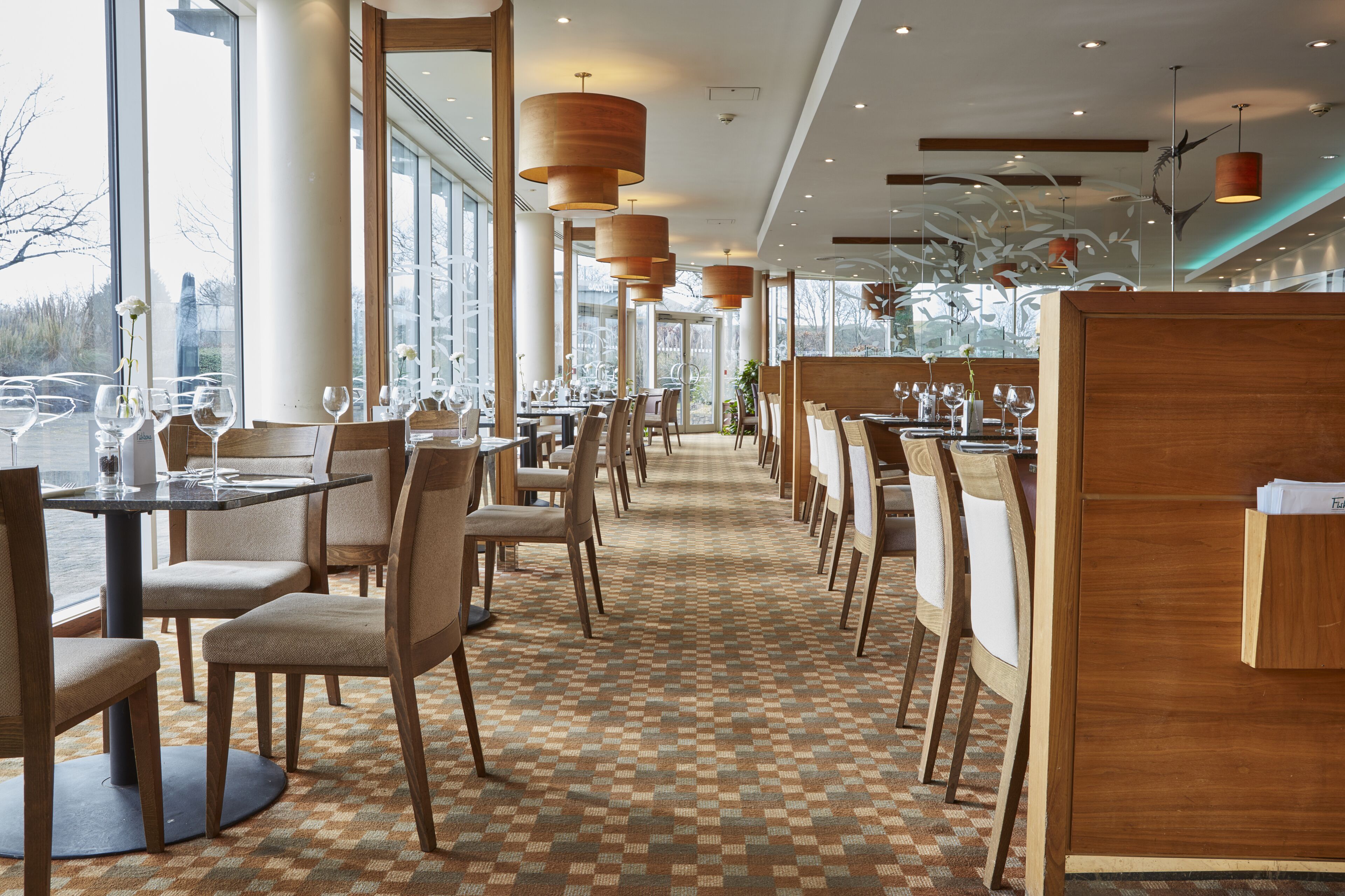 A restaurant with a checkered floor, wooden chairs, and tables.