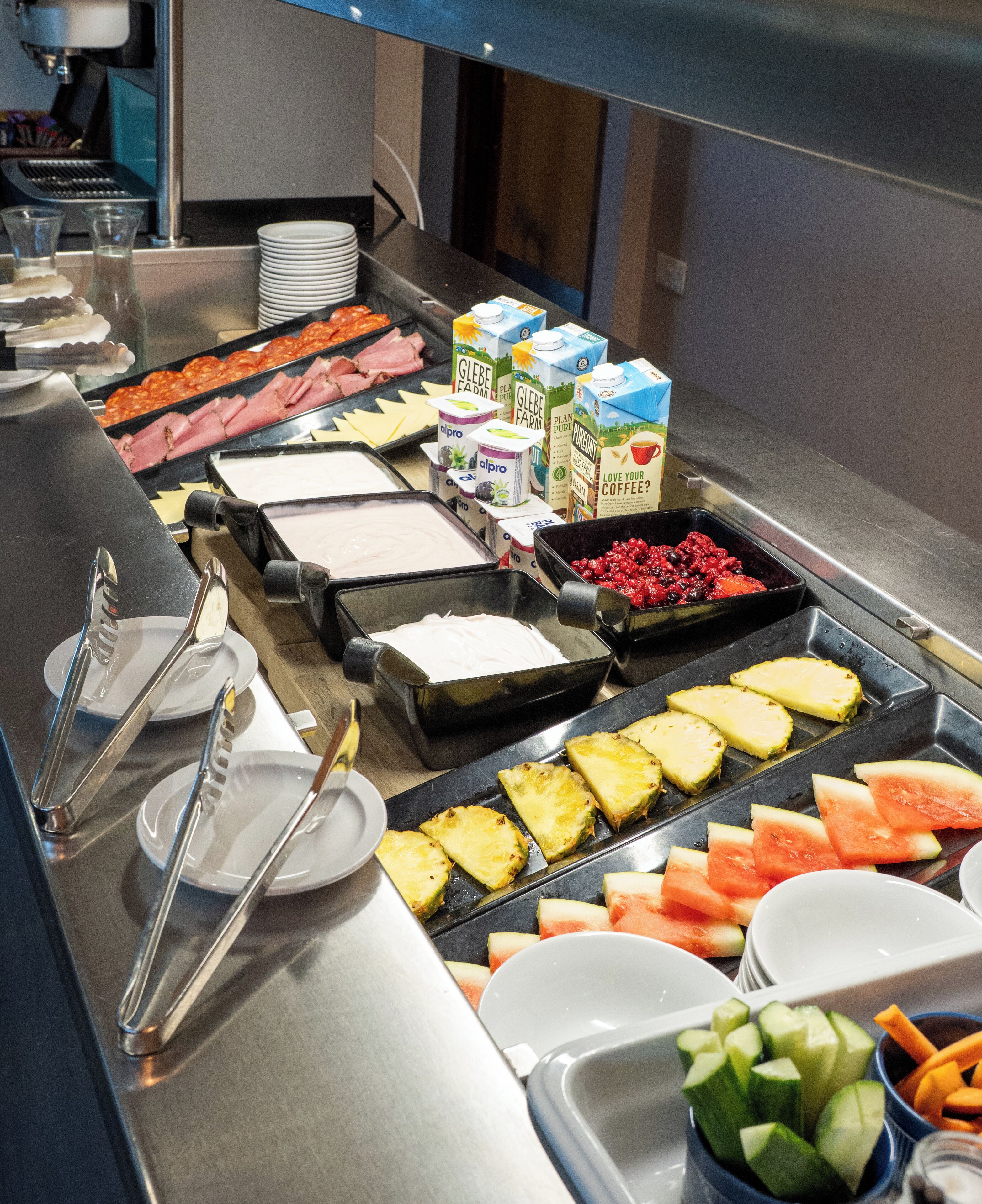 A buffet with various food items including fruits, vegetables, and dairy products.
