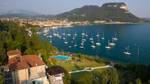 A coastal town with a marina filled with sailboats, a swimming pool, and lush greenery. - Hotel Du Parc (Garda)