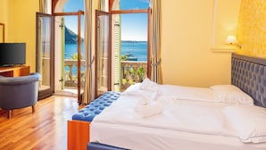 A hotel room with a bed, a TV, and a view of the sea. - Hotel Du Parc (Garda)