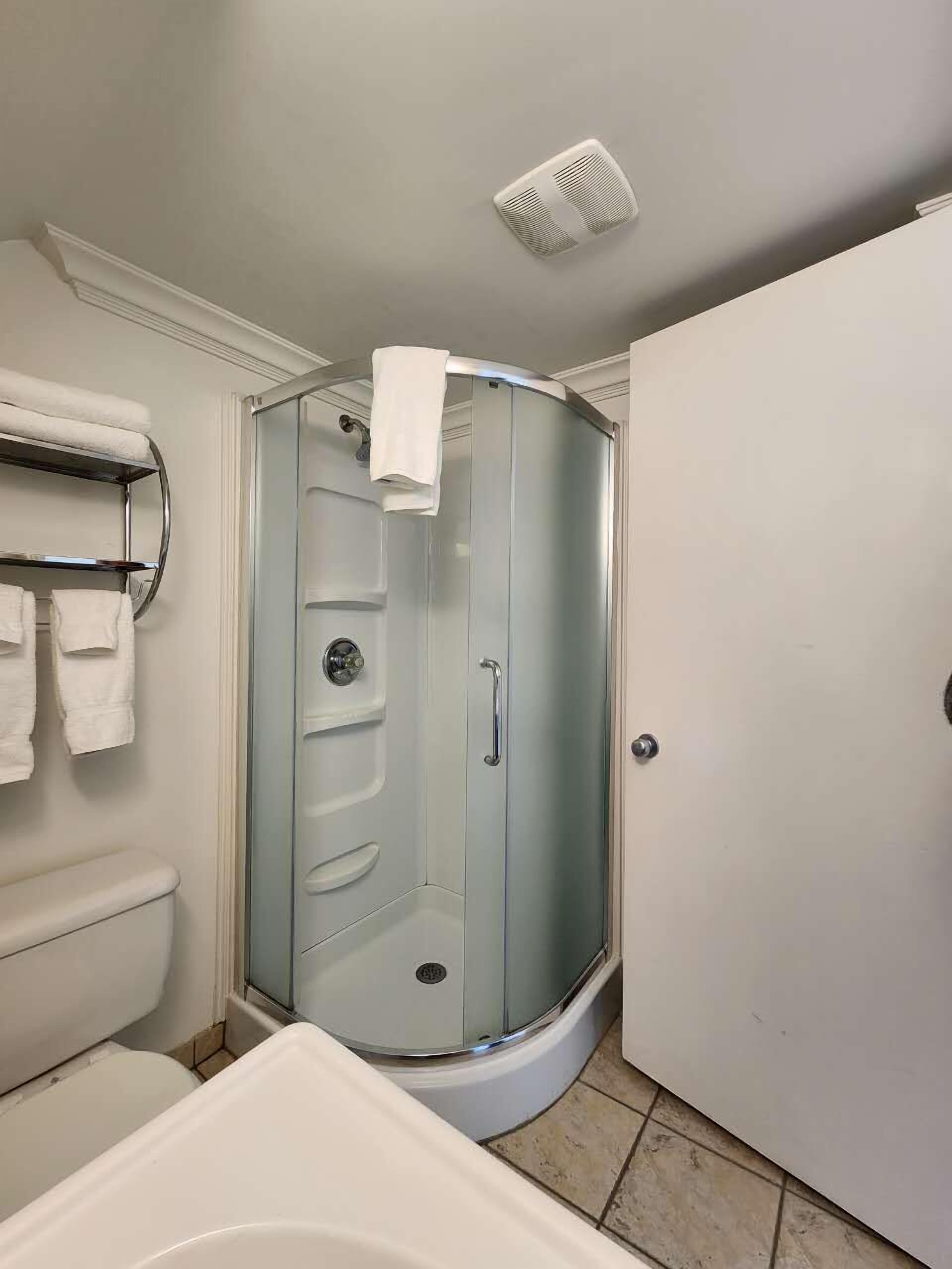 A bathroom with a glass-enclosed shower, a toilet, and a bathtub.