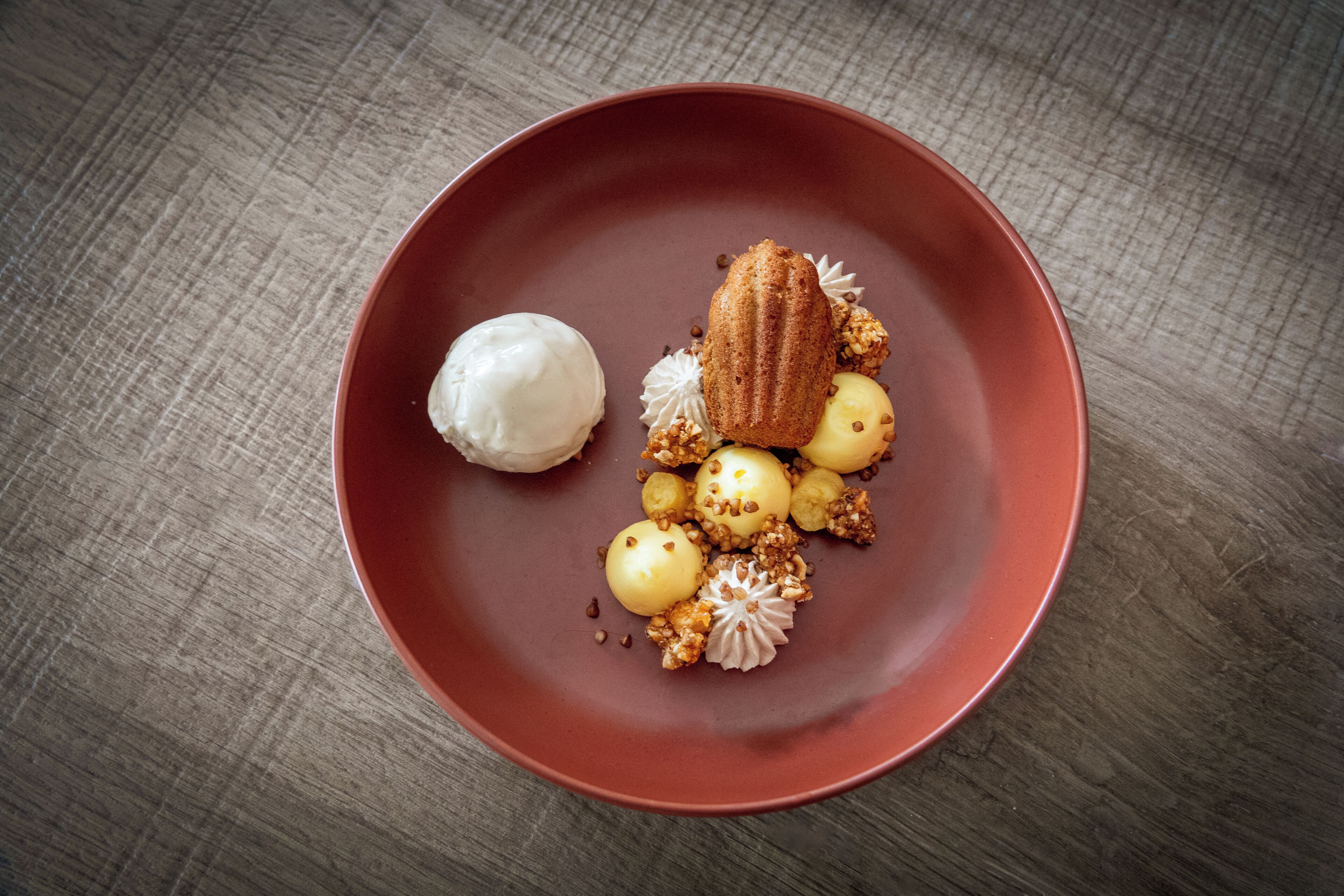 A dessert on a red plate with a wooden table background.