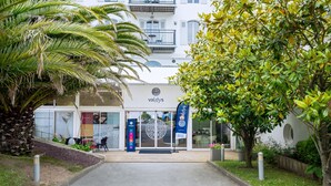 A building with a sign reading "Vallys" and a palm tree in the foreground. - Valdys Thalasso & Spa Hotel - l’Escale marine (Douarnenez)
