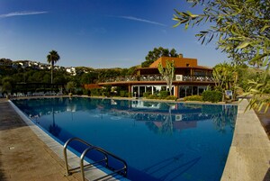 Una piscina al aire libre de temporada, sombrillas