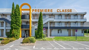 Un edificio de varios pisos con un arco de entrada destacado que dice "PREMIERE CLASSE".