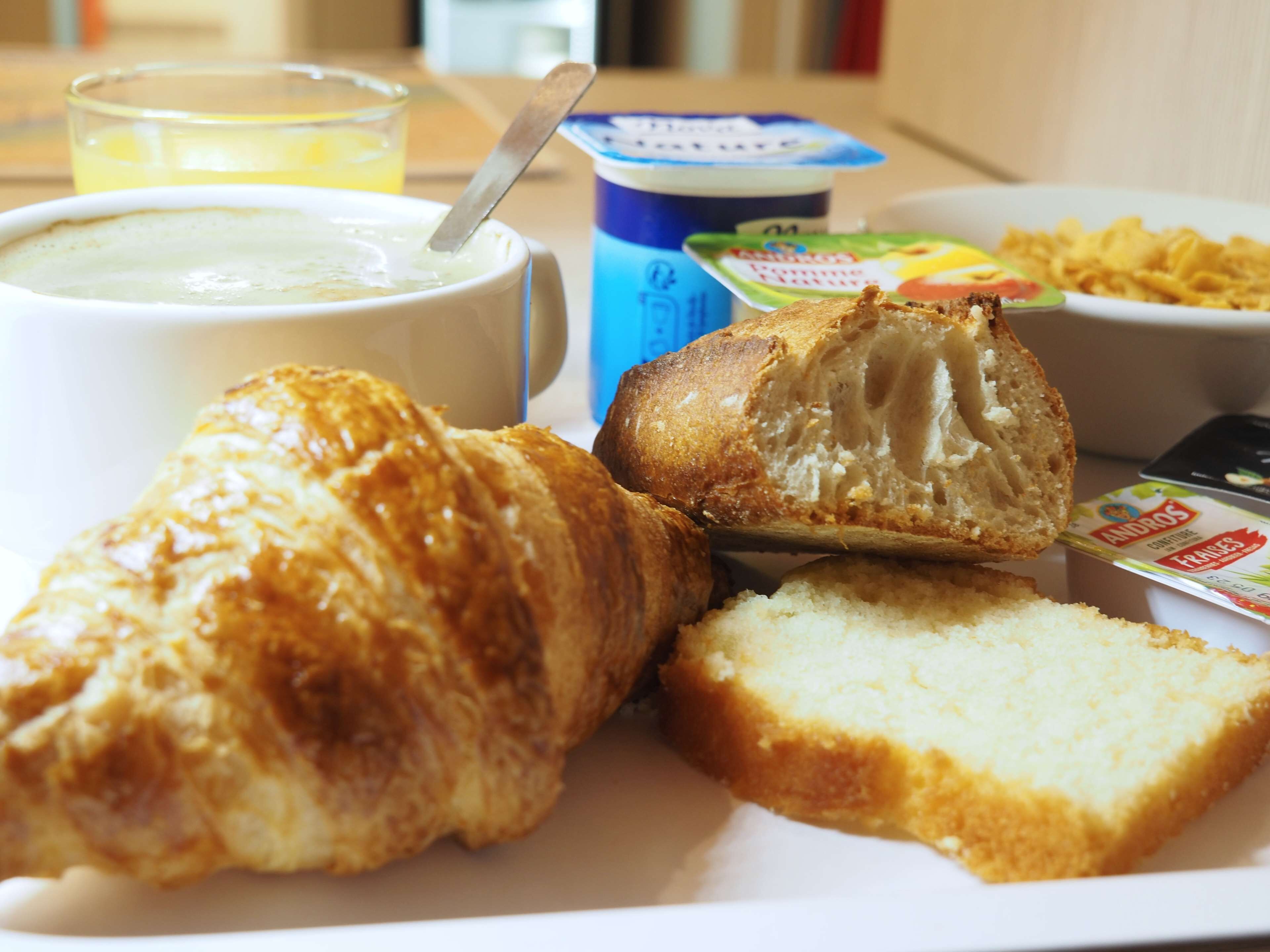 Een ontbijtje met croissant, brood en yoghurt.
