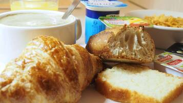 Een ontbijtje met croissant, brood en yoghurt.