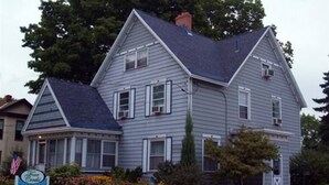 A two-story house with a gabled roof, a front porch, and a sign indicating it is a bed and breakfast. - Four Creeks Bed & Breakfast (Girard)