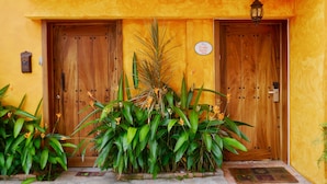 A wooden door with a sign reading "Frida Suite 244" and a small plant in front.