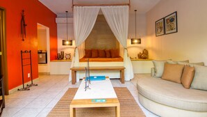 A bedroom with a bed, bedside table, and a sofa.