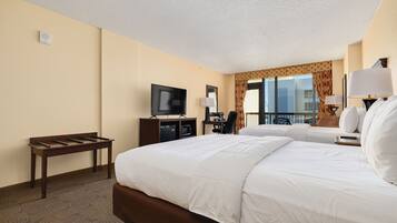 Habitación de hotel con una cama grande, un escritorio con televisor, una silla y ventana con vistas.