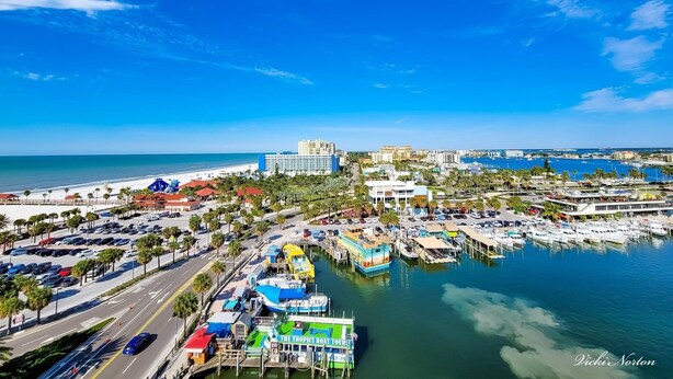 A marina with boats, a road, and buildings.