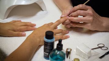 A close-up of a person receiving a manicure.