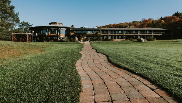 A modern building with a brick pathway leading to the entrance.