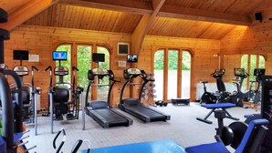 Una palestra con tapis roulant, macchinari per pesi e tappetini per esercizi.