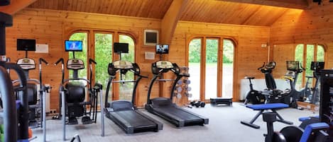 A gym with treadmills, weight machines, and exercise mats.
