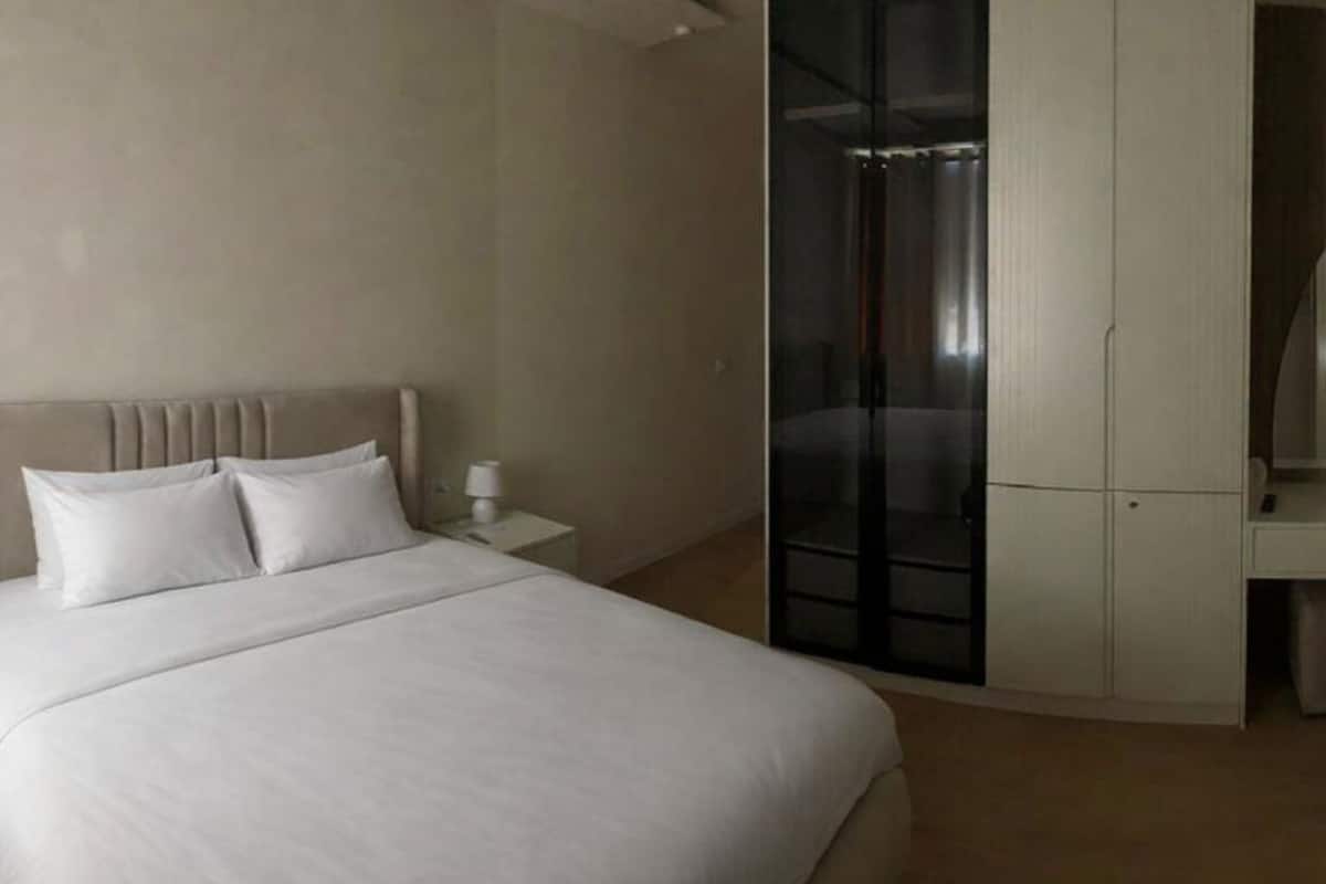 A hotel room with a bed, a nightstand, a wardrobe, and a sliding door closet.