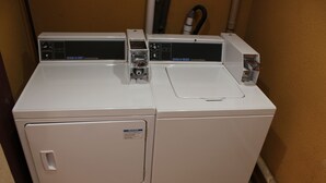 A commercial washer and dryer unit with control panels and a notice label. - Motel 6 Oklahoma City, OK - Frontier City (Oklahoma City)