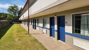 A row of single-story buildings with blue doors, likely a motel or hotel. - Motel 6 Oklahoma City, OK - Frontier City (Oklahoma City)