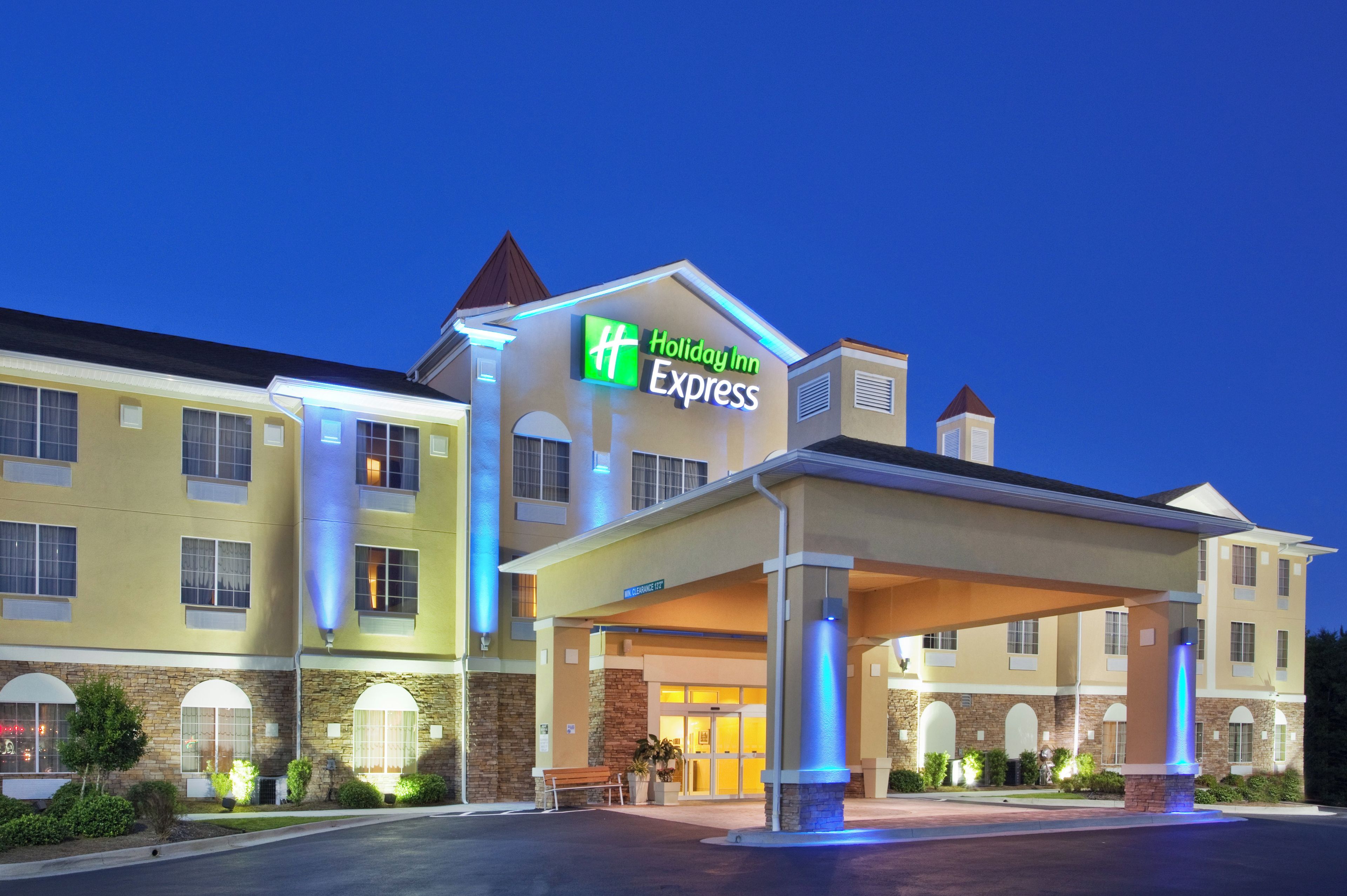 Um hotel Holiday Inn Express com entrada coberta e céu claro.