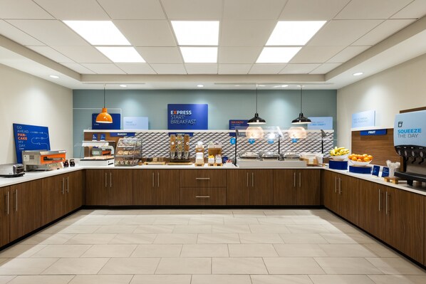A modern breakfast area with a counter, kitchen appliances, and a sign for 'EXPRESS START' breakfast. - Holiday Inn Express Savannah Airport by IHG (Savannah)