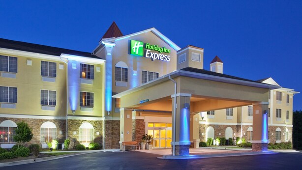 A Holiday Inn Express building with a covered entrance and a sign indicating the name. - Holiday Inn Express Savannah Airport by IHG (Savannah)
