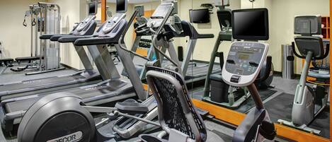 A gym with treadmills, elliptical machines, and weight machines.