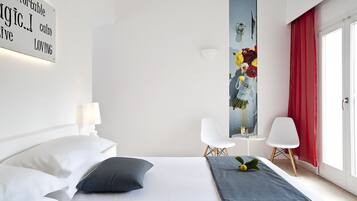 Una habitación de hotel moderna con una cama bien tendida, un cuadro en la pared y una cortina roja.