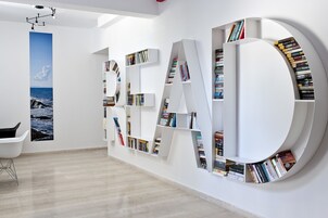 Un interior moderno con una gran estantería que deletrea 'READ' y está llena de libros.