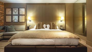 A modern hotel room with a large bed, two bedside lamps, a sofa, and a brick wall.