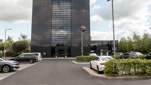 A modern building with a sign reading "Dakota" and a parking lot with several cars. - Dakota Edinburgh (South Queensferry)