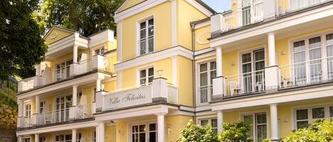 A yellow building with balconies and a sign reading "Villa Felicitas".