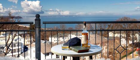 A balcony with a table, a bottle, and a book.