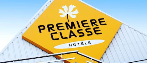 A yellow sign with "Premiere Classe Hotels" and a maple leaf logo.
