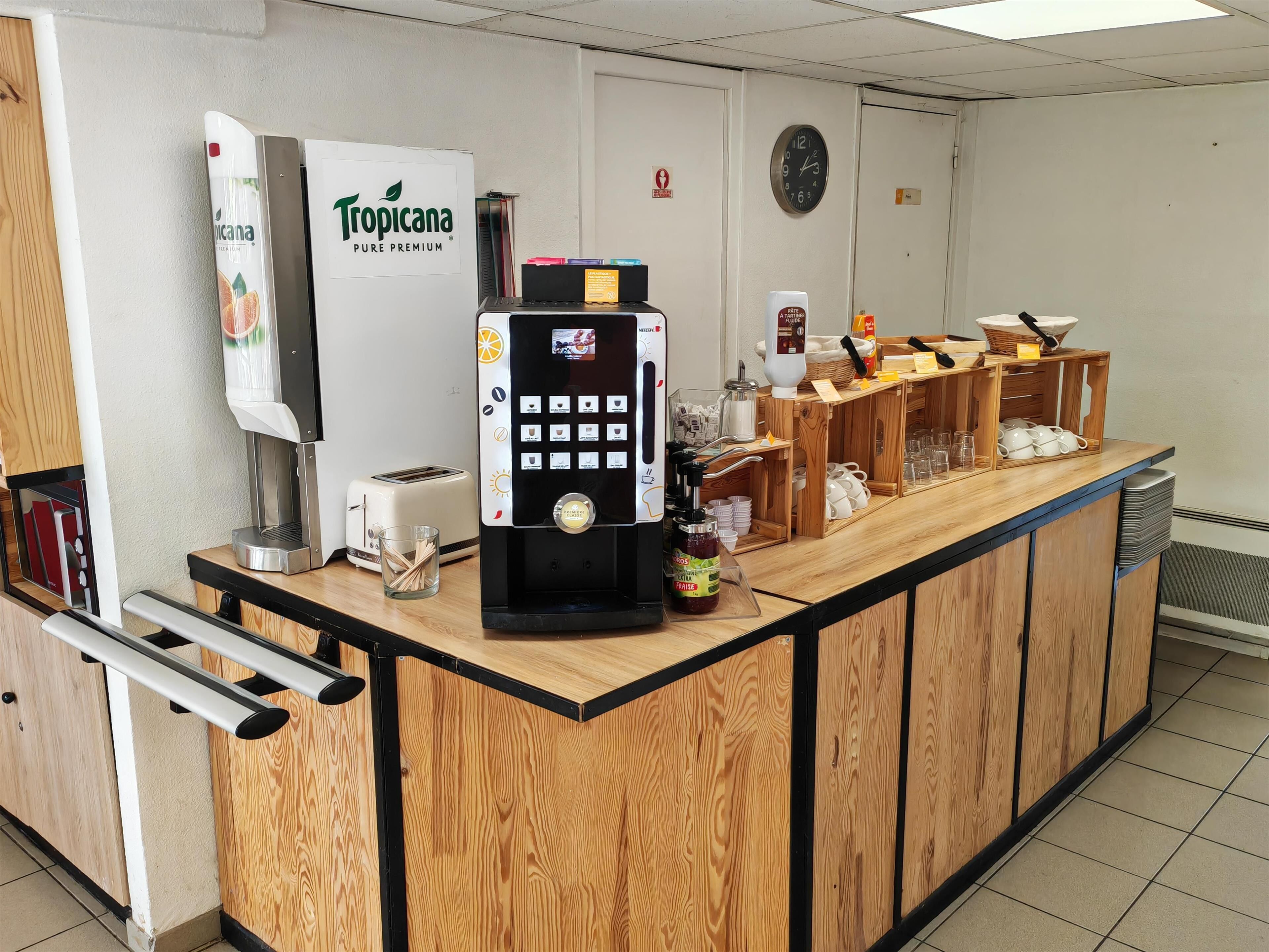 A self-service coffee station with a Tropicana Pure Premium dispenser, a coffee machine, and a toaster.
